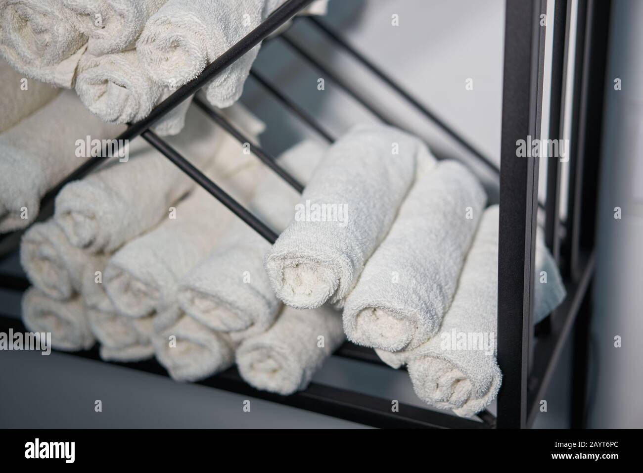 https://c8.alamy.com/comp/2AYT6PC/white-clean-towels-rolled-up-on-a-roll-are-stored-on-shelves-in-a-beauty-salon-in-a-barbershop-spa-close-up-towel-storage-2AYT6PC.jpg