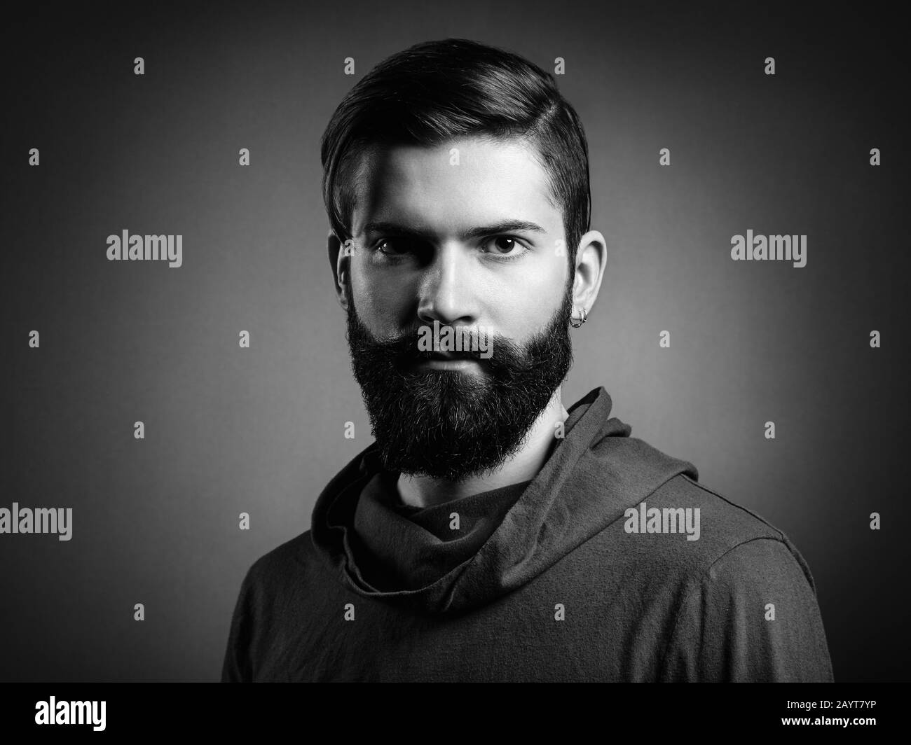 Portrait of handsome man with beard and mustache. Close-up image of serious brutal bearded man on dark background. Black and white photography Stock Photo