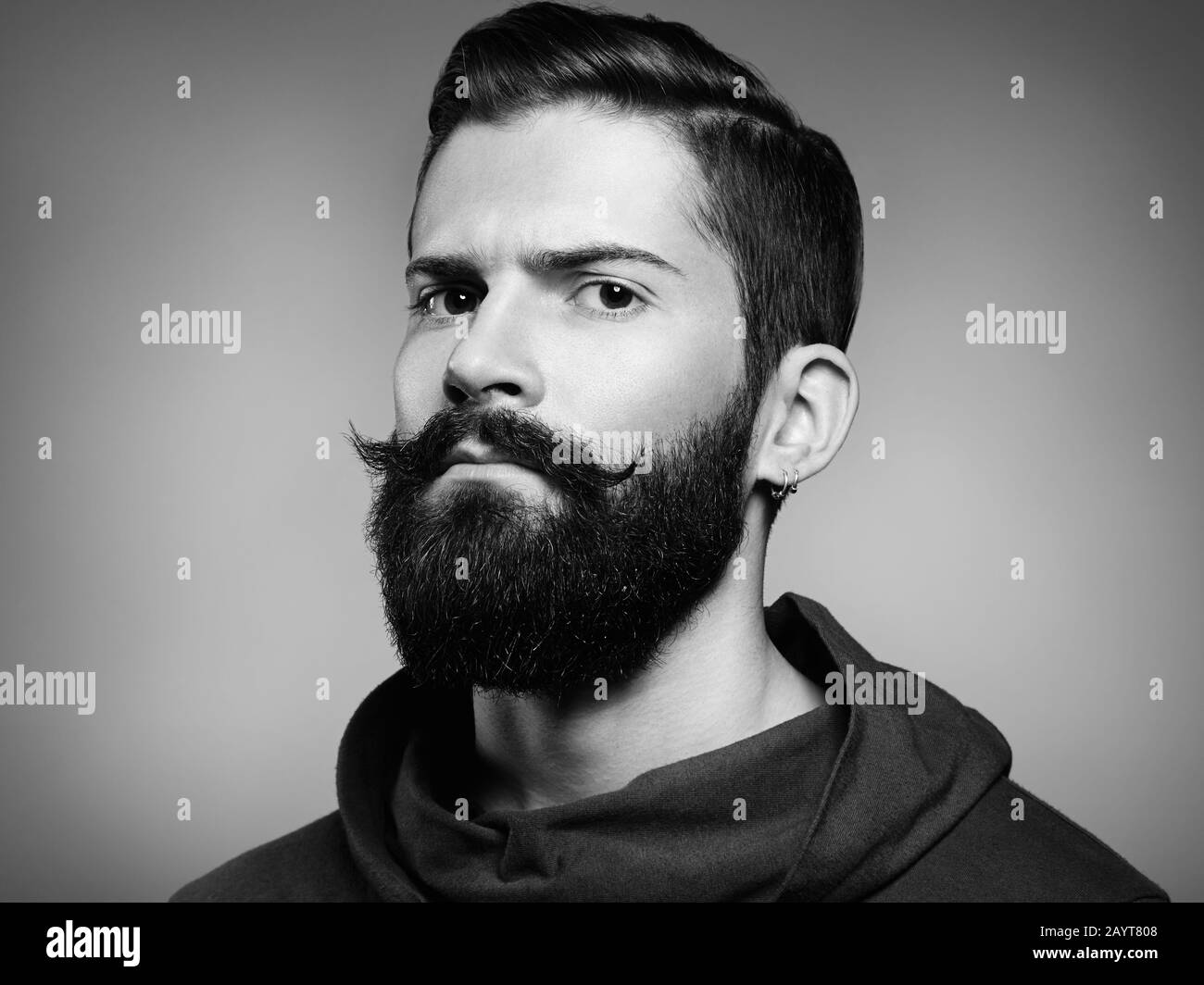 Portrait of handsome man with beard and mustache. Close-up image of serious brutal bearded man on dark background. Black and white photography Stock Photo