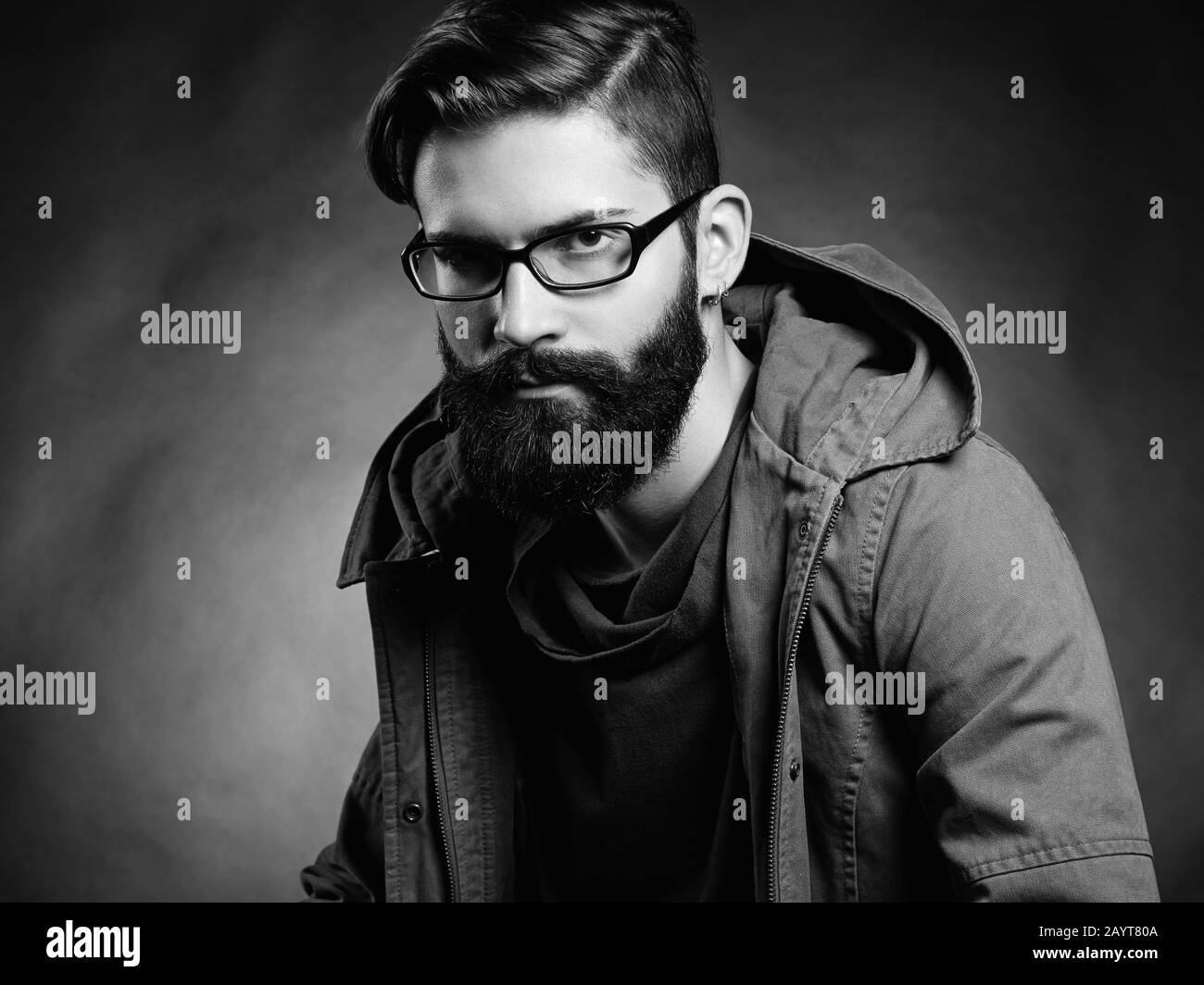 Portrait of handsome man with beard and mustache. Close-up image of serious brutal bearded man on dark background. Man with glasses. Black and white p Stock Photo
