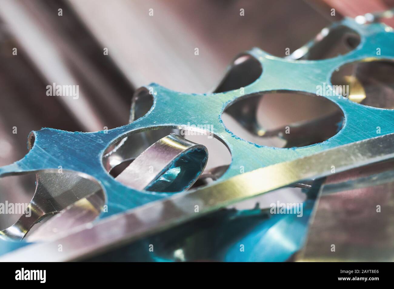 Aluminium sheet scraps with holes and blue protective film, production waste close-up photo Stock Photo
