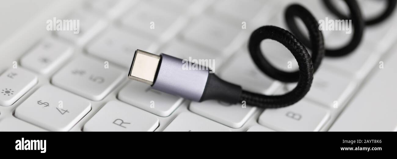 Usb type c cable against laptop keyboard background. Stock Photo
