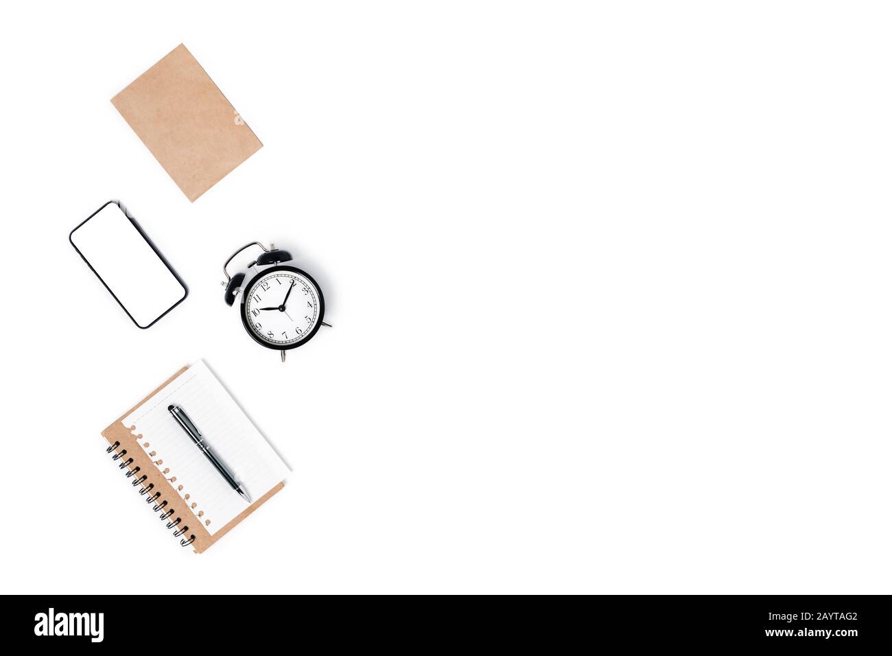 Modern workspace with smartphone, notepad, pen and alarm clock. Flat lay, top view, copy space. Stock Photo