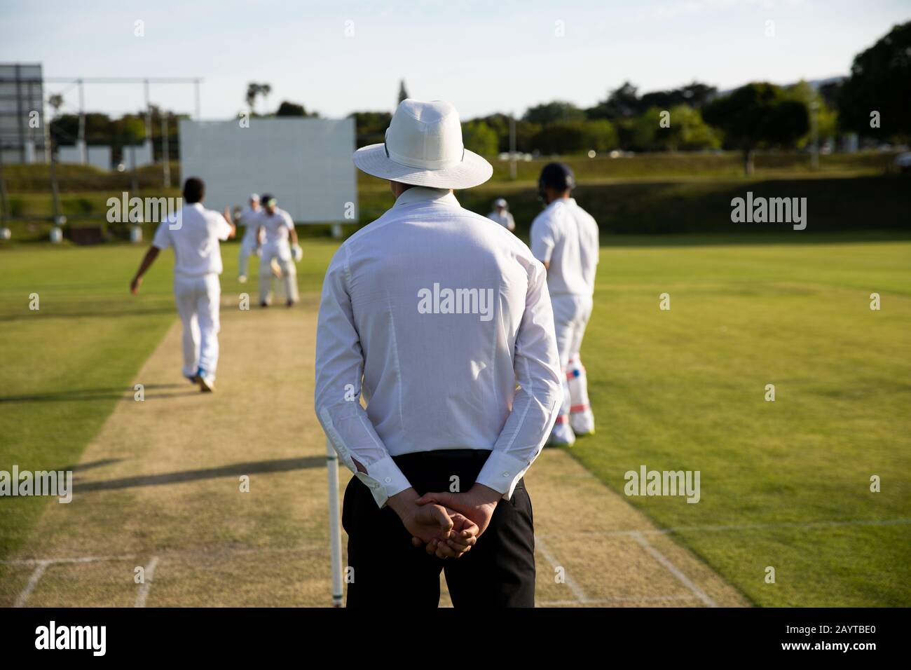 Cricket umpire watching the players during match Stock Photo