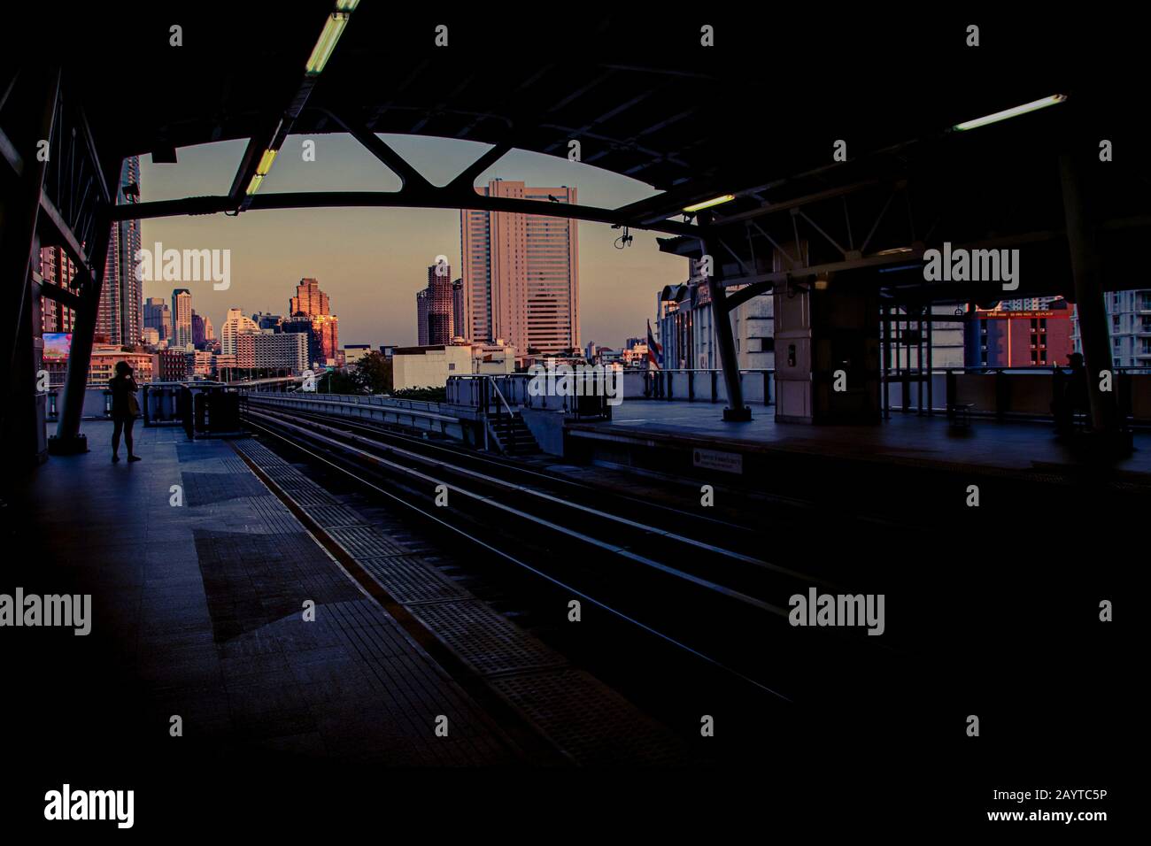 Cinematic cityscape of Bangkok City showing the railway track leading to the city center during dusk Stock Photo