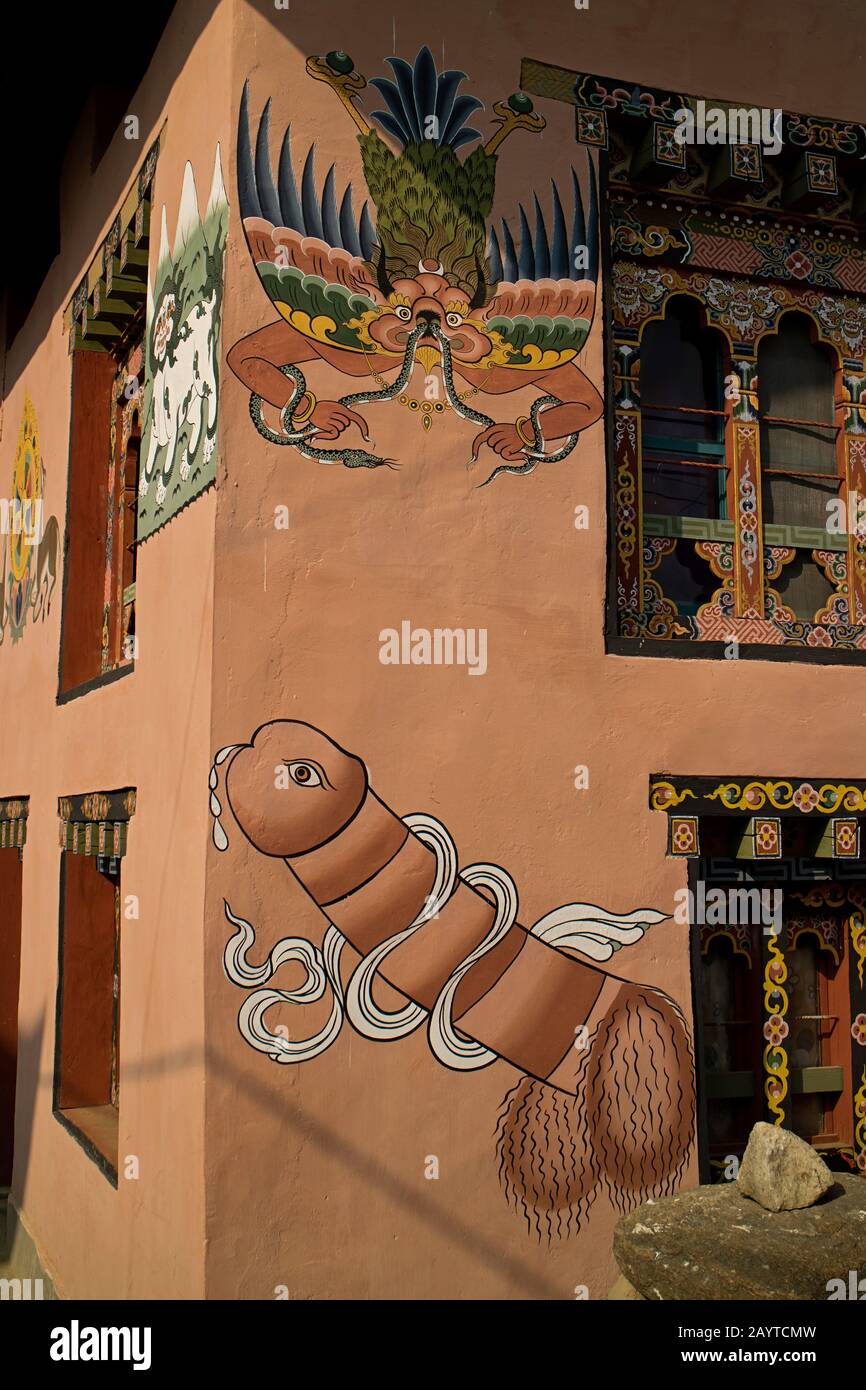Paintings of the immortal Garuda is eating the mythical snake Naga and a Phallus on a rural bhutanese wall Stock Photo