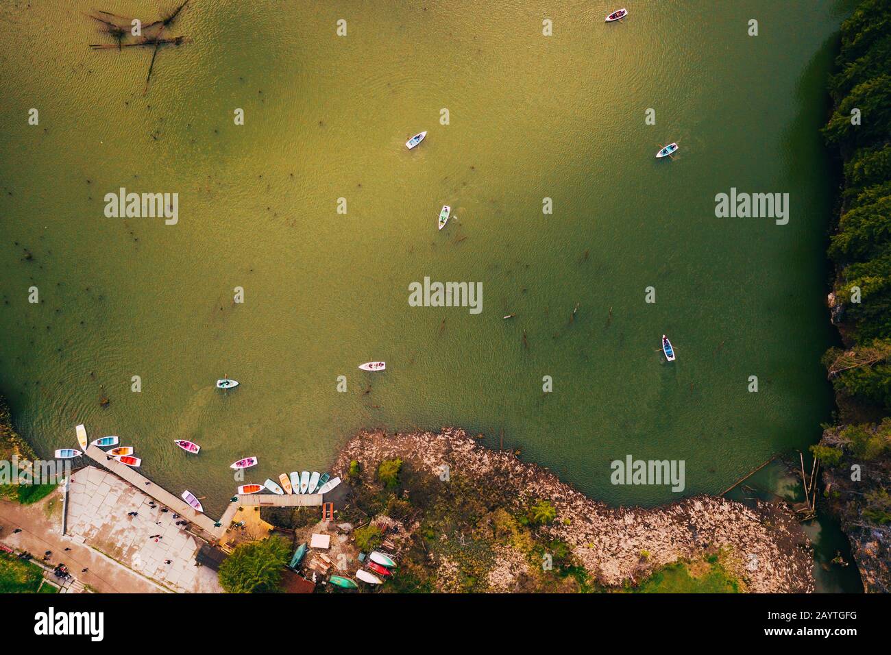 Lake ina pine tree forest with small boats seen from a drone Stock Photo