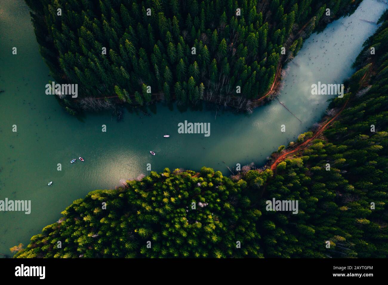 Lake ina pine tree forest with small boats seen from a drone Stock Photo