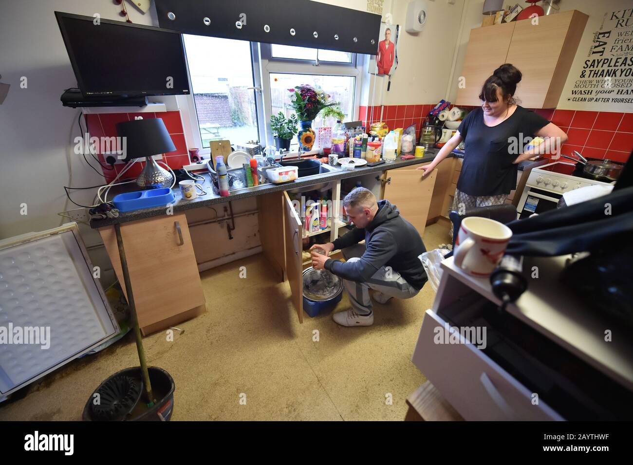 Lee Griffiths and Michelle Jones emptying out cupboards after flooding damaged their house on Rhyd-Yr-Helyg road in Nantgarw, south Wales, where residents are returning to their homes to survey and repair the damage in the aftermath of Storm Dennis. Stock Photo