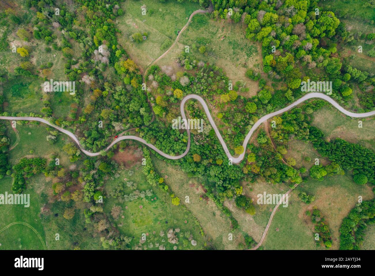 Drone view of green meadows, small houses and roads in Transylvania, Romania. Stock Photo