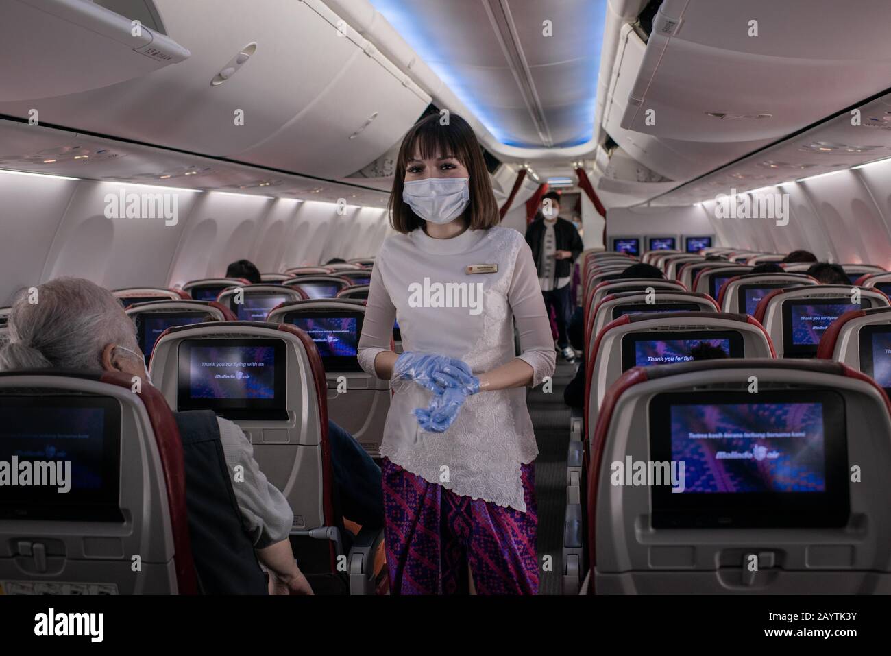 Hong Kong, China. 14th Feb, 2020. An airline staff wears surgical mask inside an airplane at the Hong Kong International Airport.As the number of victims of the new Coronavirus increases, more countries cancel flights within and without the region. Credit: Ivan Abreu/SOPA Images/ZUMA Wire/Alamy Live News Stock Photo