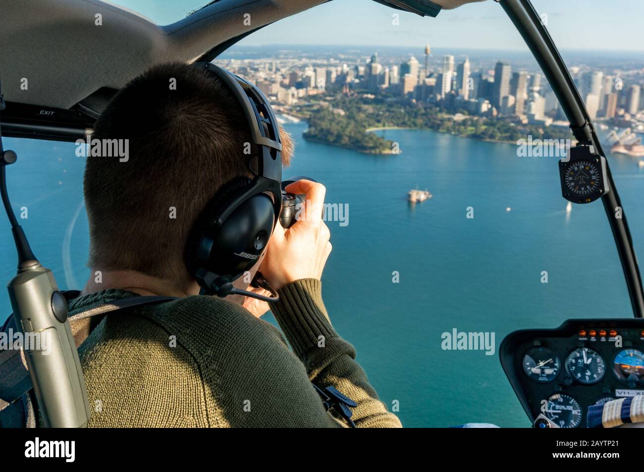 Sydney, Australia - June 18, 2014: Caucasian man taking photos of Sydney CBD and Sydney Harbour from helicopter. Tourist in front seat in helicopter p Stock Photo