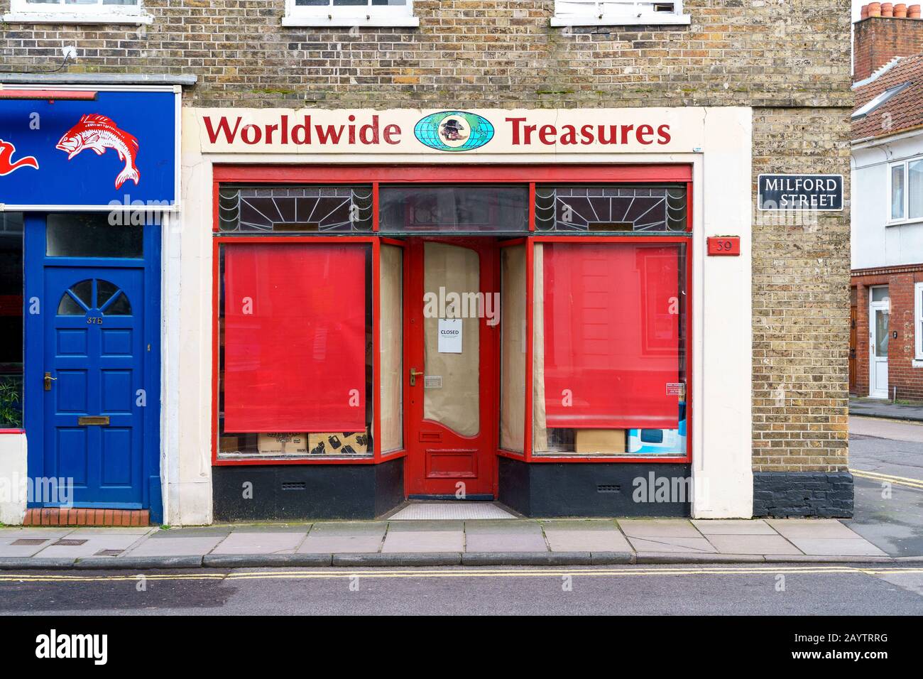 Red blinds in the windows of a closed down shop Stock Photo