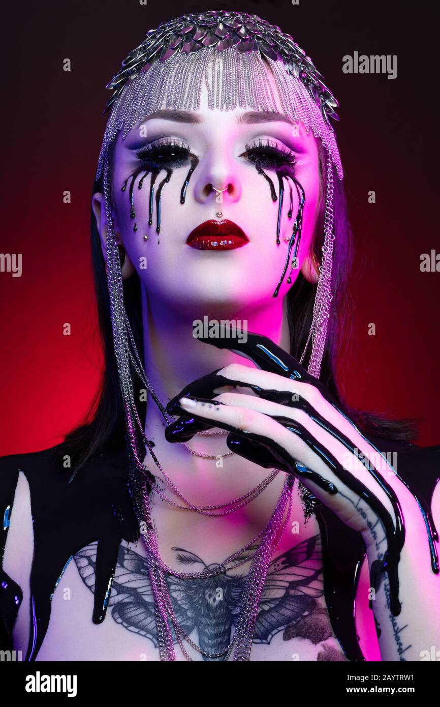 Colorful portrait of a young gothic woman crying with black blood Stock Photo