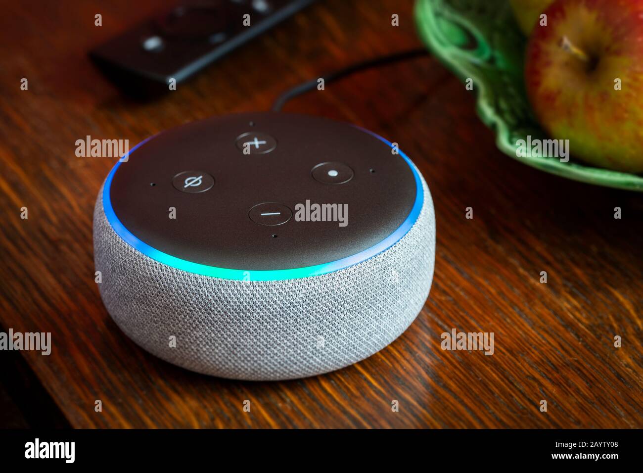 BATH, UK - FEBRUARY 17, 2020 : Close up of a 3rd generation Amazon Echo Dot glowing blue on a table in a domestic environment Stock Photo