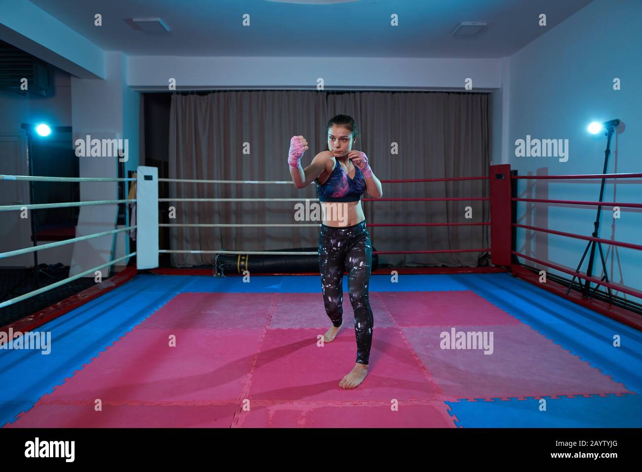 Kickboxer girl shadow boxing in the ring before sparring Stock Photo