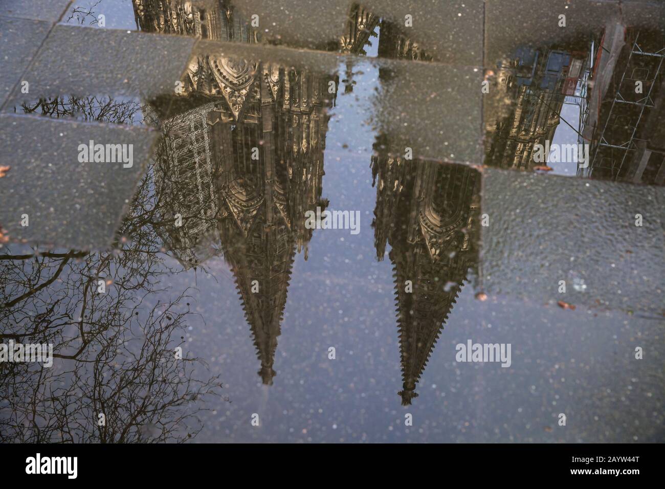 the steeples of the cathedral are reflected in a puddle, Cologne, Germany.  die Tuerme des Doms spiegeln sich in einer Pfuetze, Koeln, Deutschland. Stock Photo