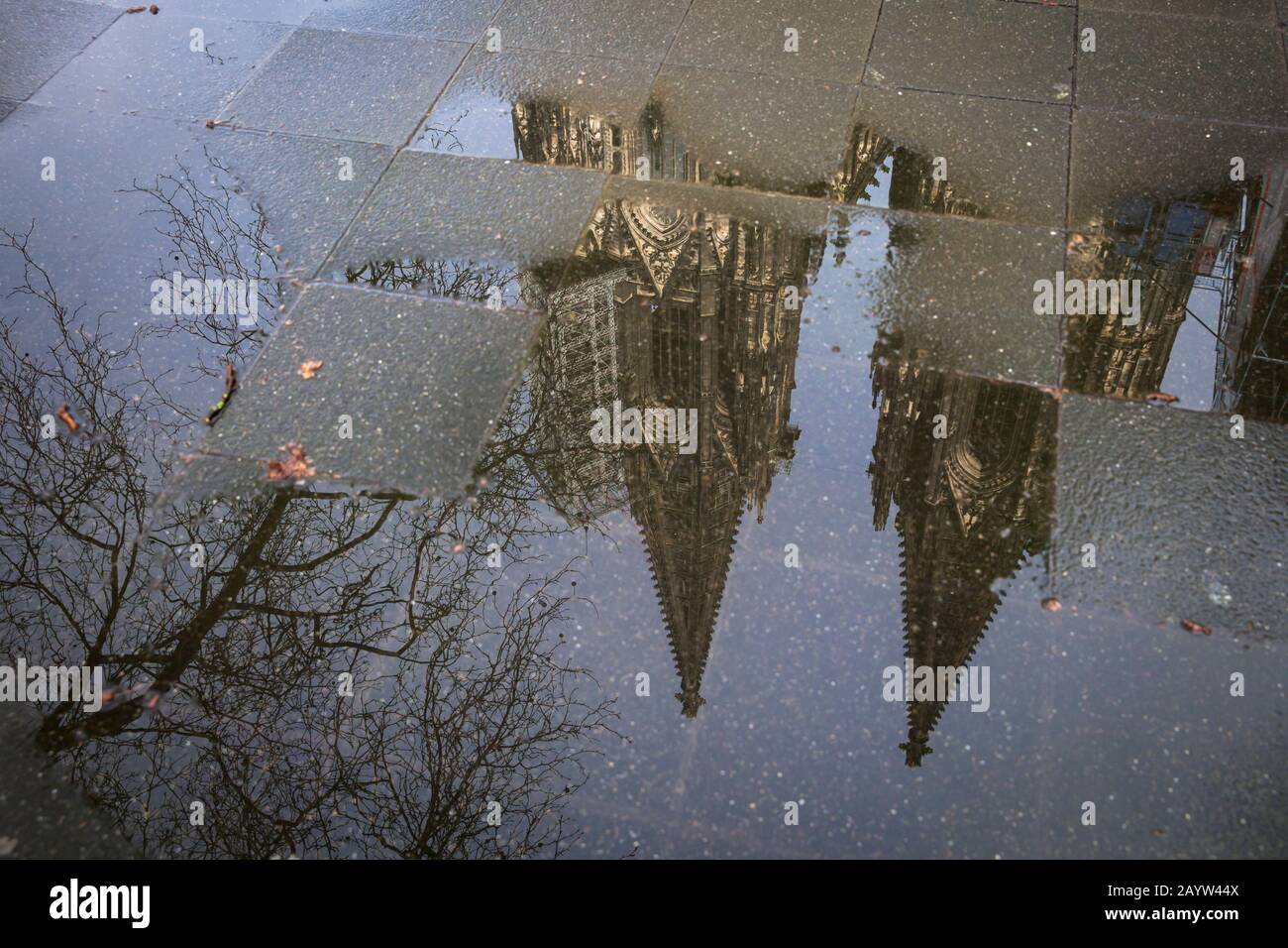 the steeples of the cathedral are reflected in a puddle, Cologne, Germany.  die Tuerme des Doms spiegeln sich in einer Pfuetze, Koeln, Deutschland. Stock Photo