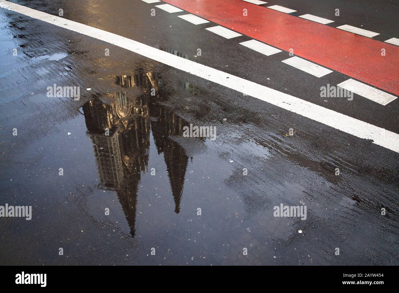 the steeples of the cathedral are reflected in a puddle, Cologne, Germany.  die Tuerme des Doms spiegeln sich in einer Pfuetze, Koeln, Deutschland. Stock Photo