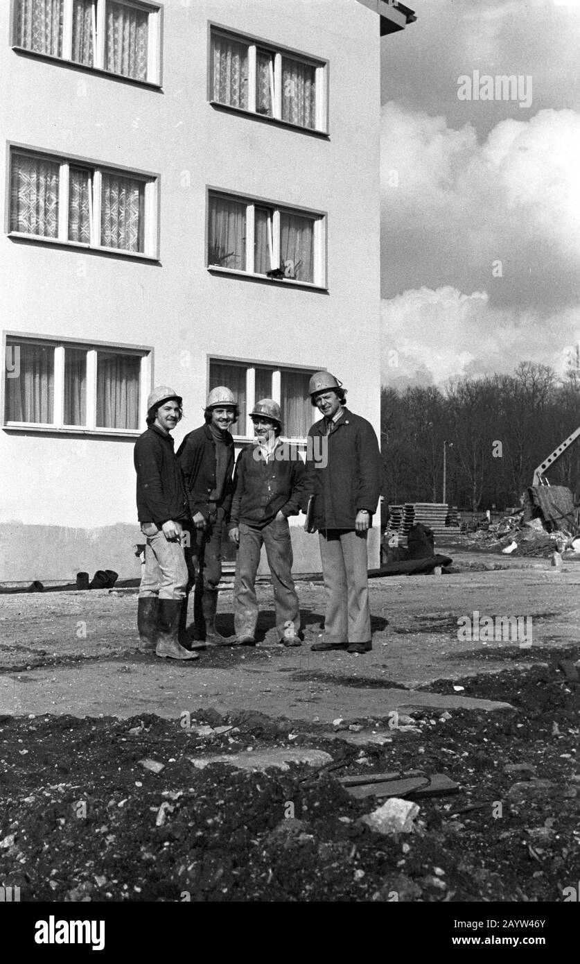 01 January 1980, Saxony, Leipzig: Young construction workers wearing construction helmets stand on a building site and present themselves to the photographer as a young collective of newcomers. In the companies these were promoted in connection with the fair of the masters of tomorrow. Exact date of recording not known. Photo: Volkmar Heinz/dpa-Zentralbild/ZB Stock Photo