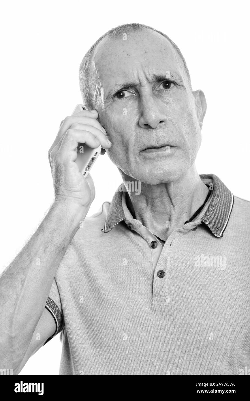 Face of angry senior man talking on mobile phone Stock Photo