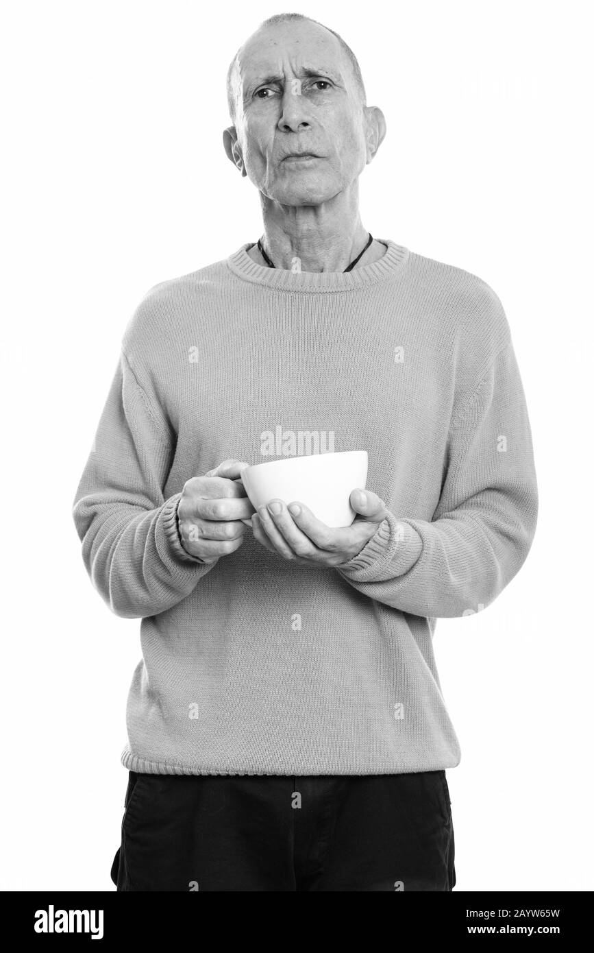 Studio shot of angry senior man holding coffee cup Stock Photo