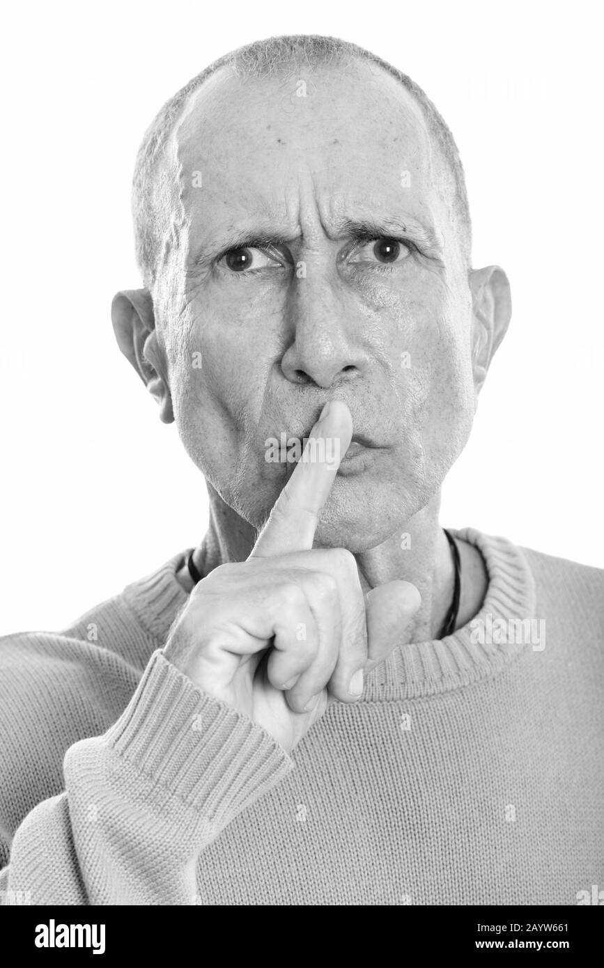 Face of angry senior man with finger on lips Stock Photo