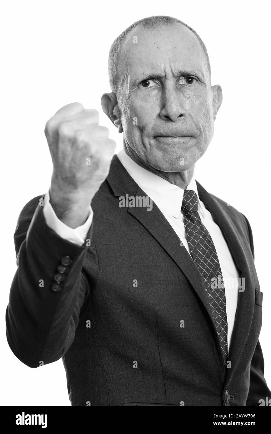 Studio shot of angry senior businessman with fist raised Stock Photo