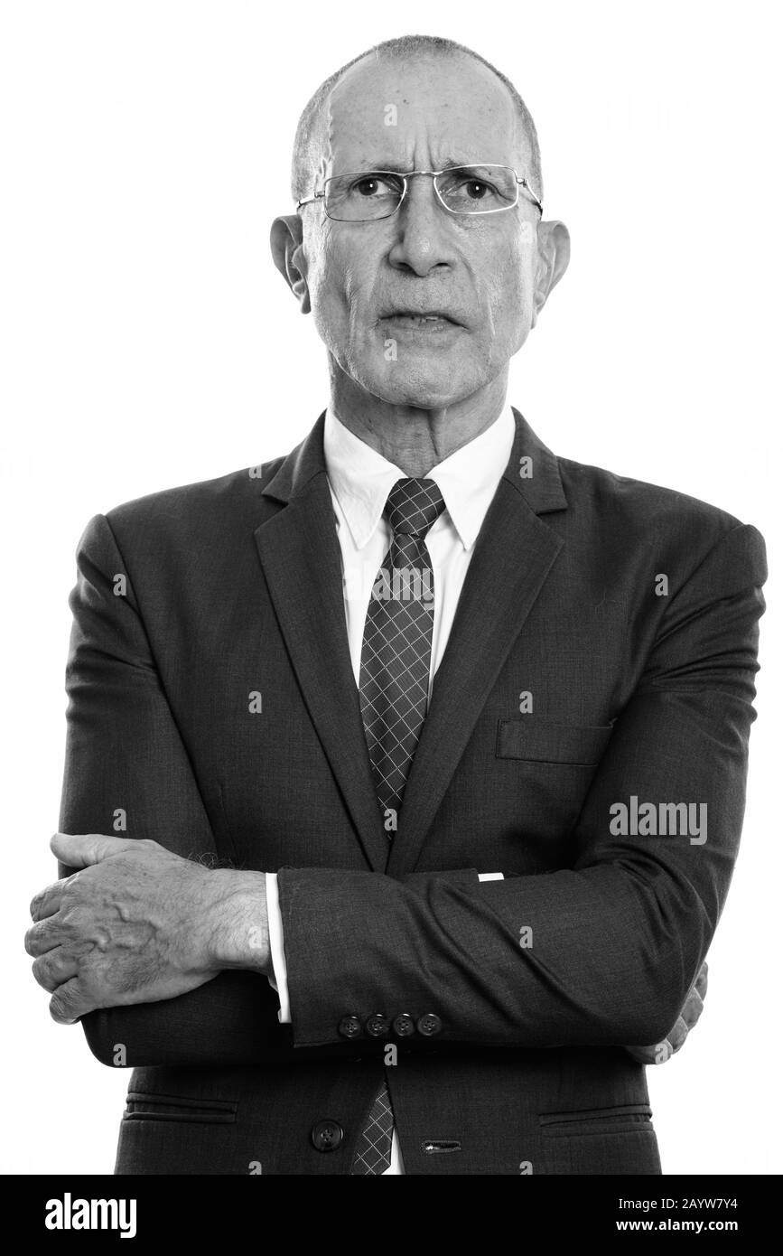 Studio shot of angry senior businessman with arms crossed Stock Photo