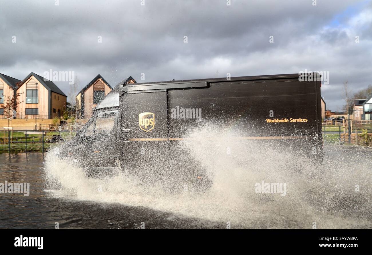 A UPS delivery van passes through a flooded road as the water rises