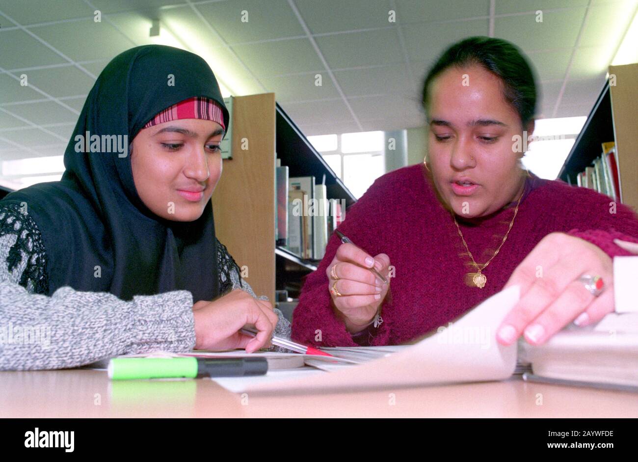Two female students studying in the library Stock Photo - Alamy