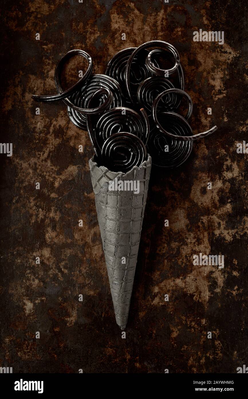 Dark fine art ice cream concept with spiral liquorice coils and a grey