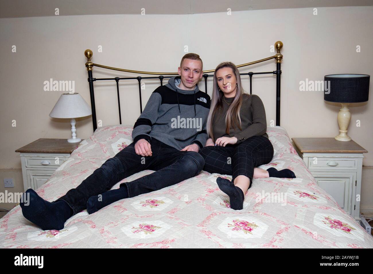 Jemma Nicklin, 23, with her partner Kieran Parker, 24, trying out one of the bedrooms during her first visit to Shrubbery Farm in Longnor near Shrewsbury, a 300-year-old four bedroom farmhouse which she won after buying two £2 tickets in a raffle organised by owner Mike Chatha. Stock Photo