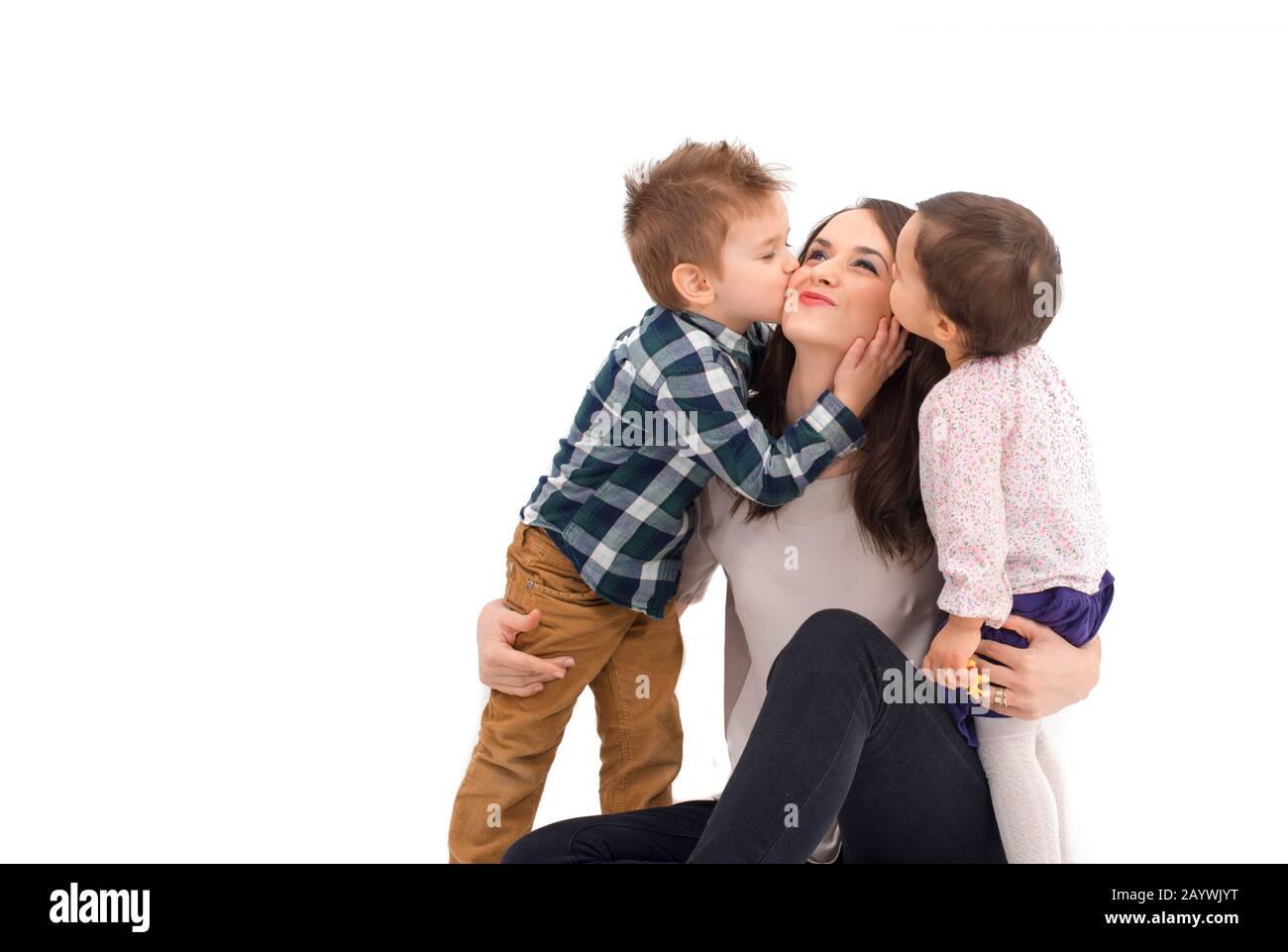 little girl and boy kissing their mother Stock Photo