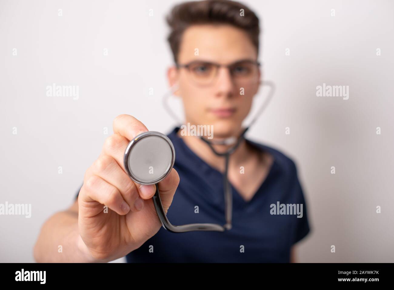 Handsome young medic holding a stethoscope, isolated over white Stock Photo