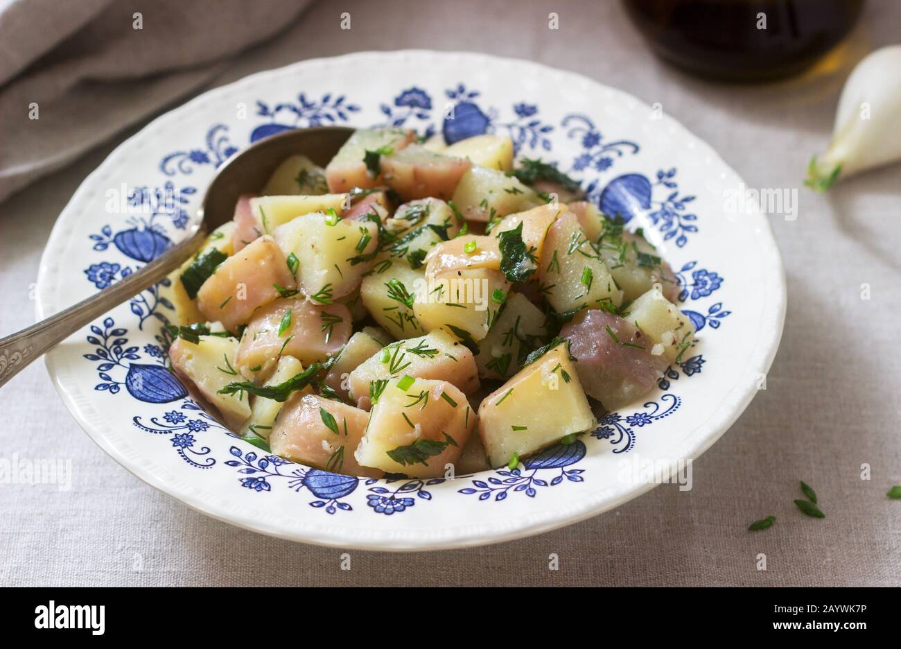 Traditional cold potato salad with onions and herbs on a linen ...