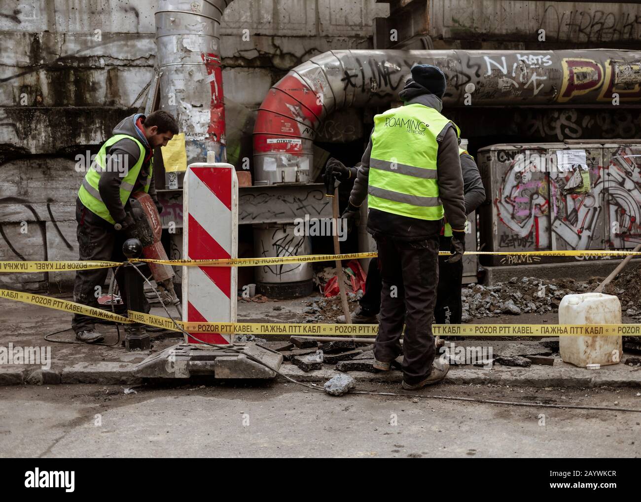 Belgrade, Serbia, Feb 7, 2020: Construction workers drilling and digging concrete sidewalk Stock Photo
