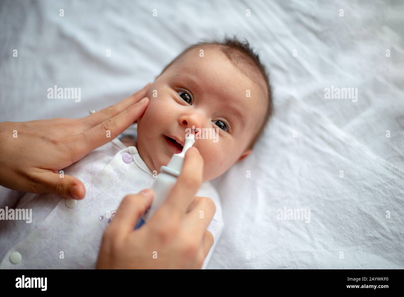 Woman using nasal spray for baby Stock Photo