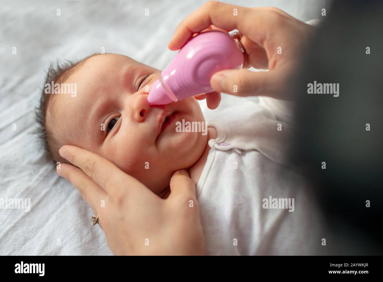 mother using baby nasal aspirator mucus nose suction Stock Photo