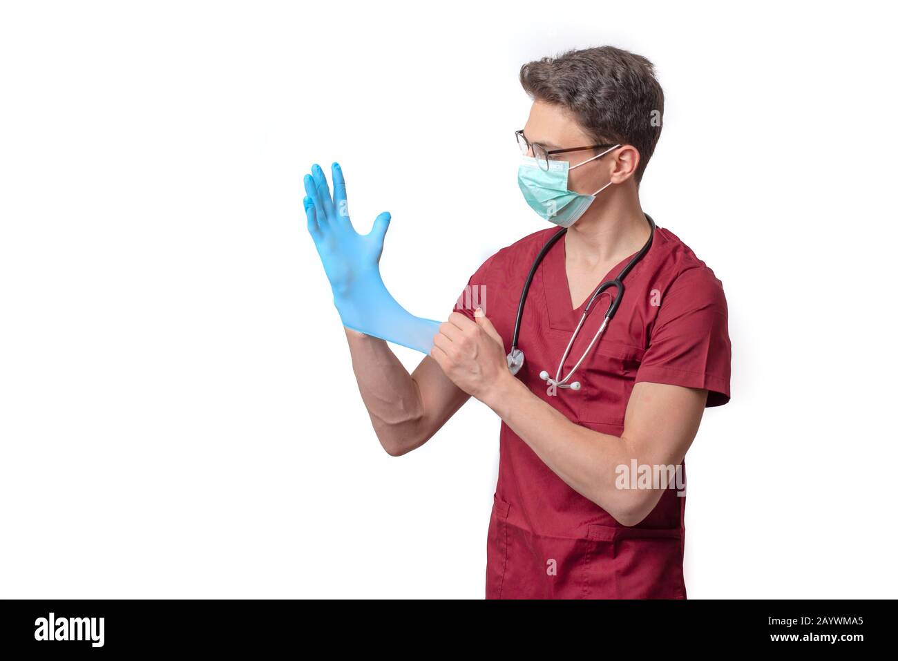 young doctor in uniform getting ready to work putting on gloves isolated on a white background Stock Photo