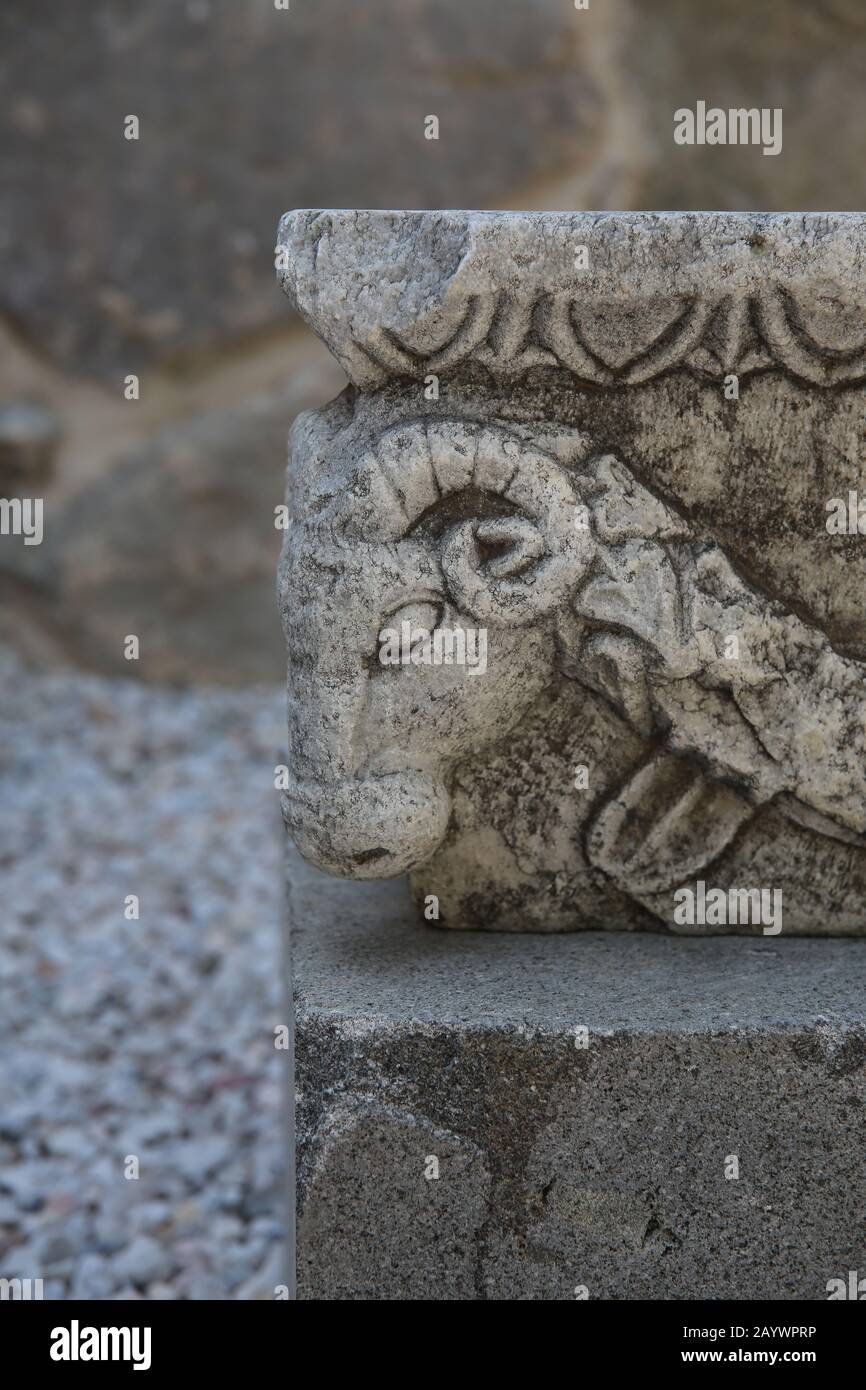 Well-head (classical puteal). Reliefs of goats 'head with garlands. Castle of Bodrum. Turkey. Stock Photo