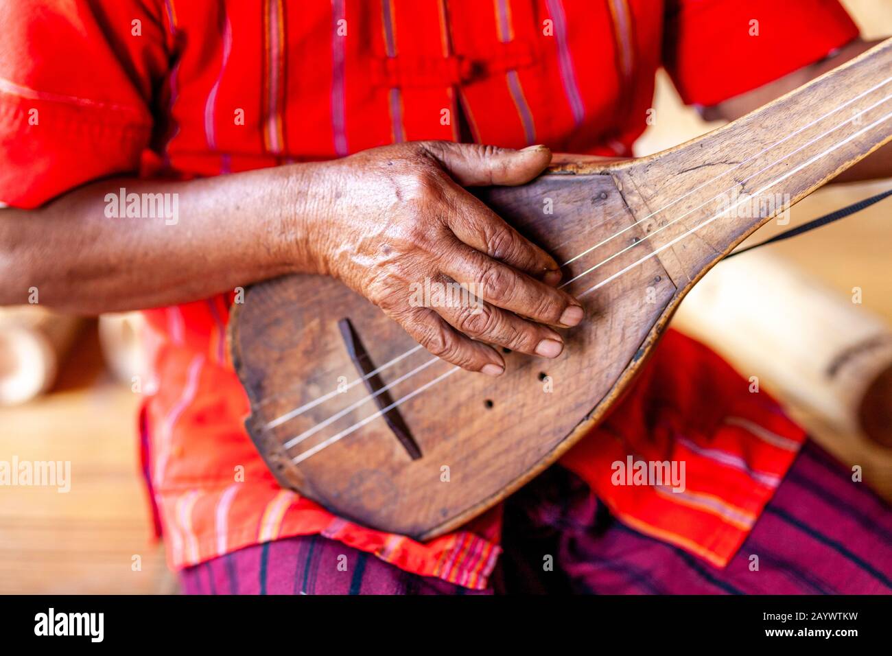 A Man From The Kayah Ethnic Group Playing A Guitar Like Instrument, Hta Nee La Leh Village, Loikaw, Kayah State, Myanmar. Stock Photo