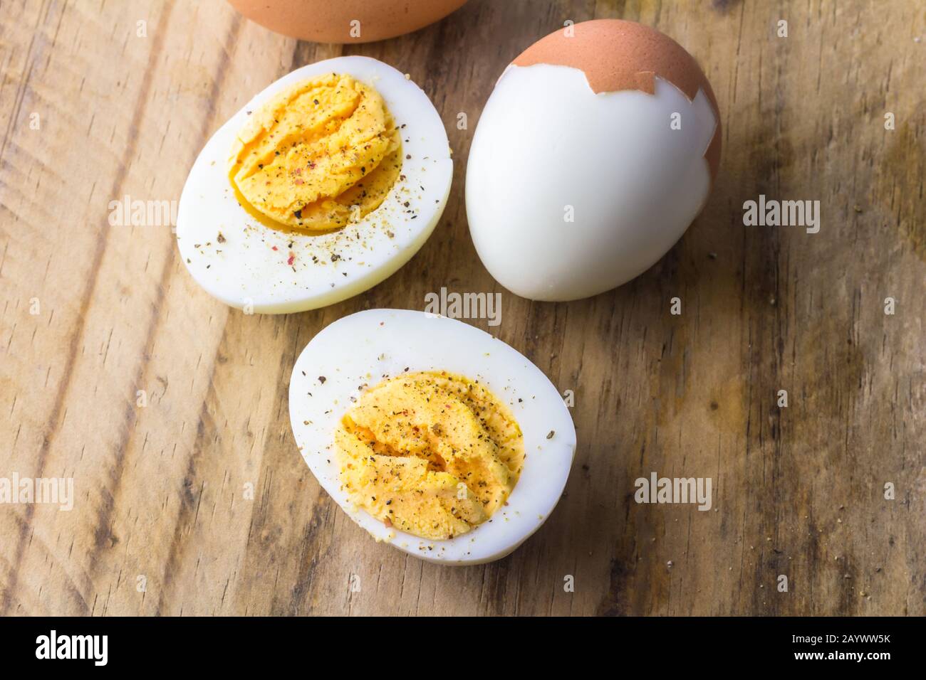 Boiled chicken eggs on wooden board with pepper flakes Stock Photo