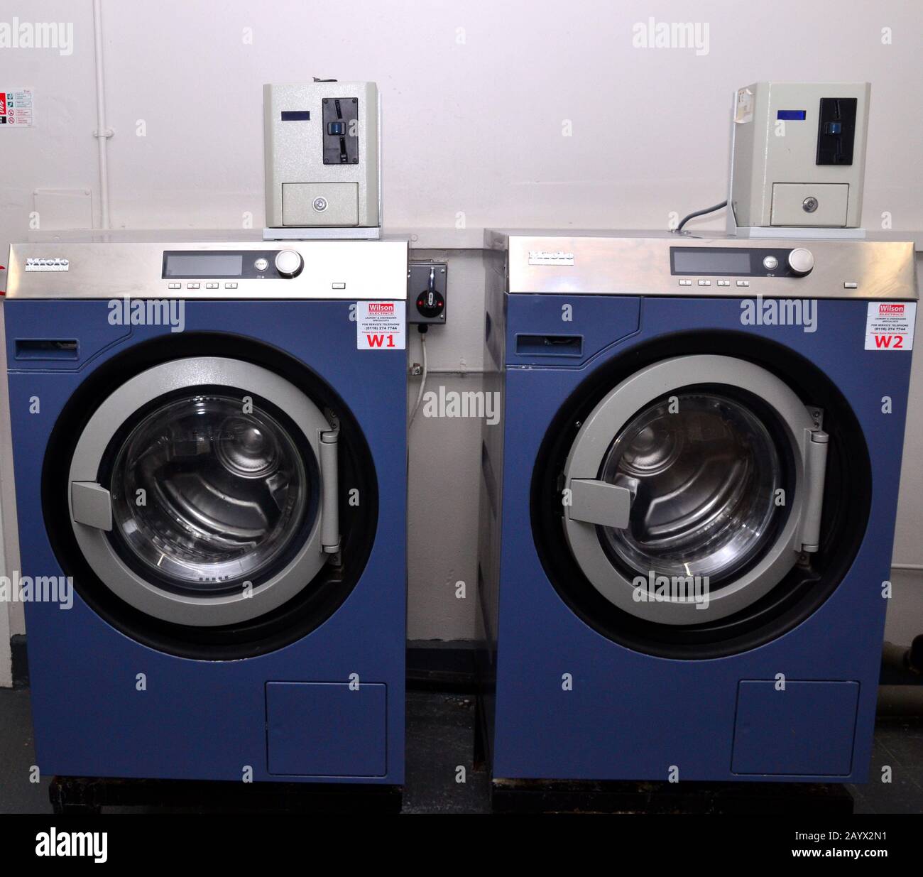 The front of two, large, empty, front loading, coin operated washing machines Stock Photo