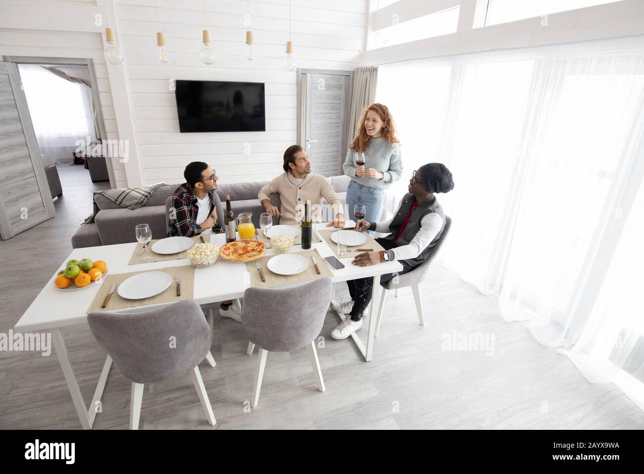 Group of young multi-ethnic friends gathering together to drink wine at ...