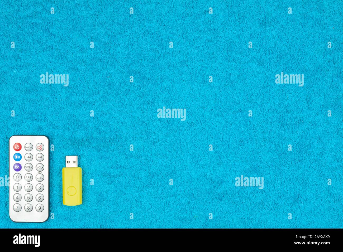 A flash drive and a small control panel are on a colored background. Stock Photo