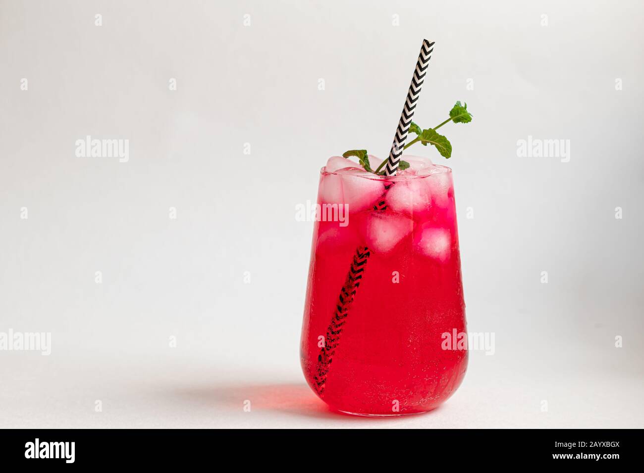 Raspberry-barberry drink in a transparent glass with ice. Added palm ...