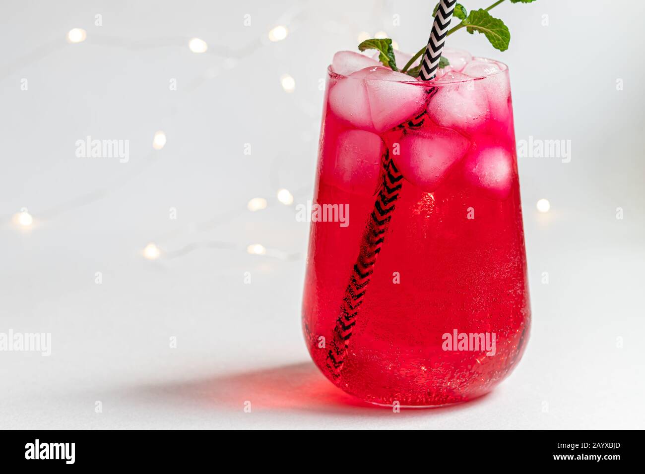 Raspberry-barberry drink in a transparent glass with ice. Added palm ...