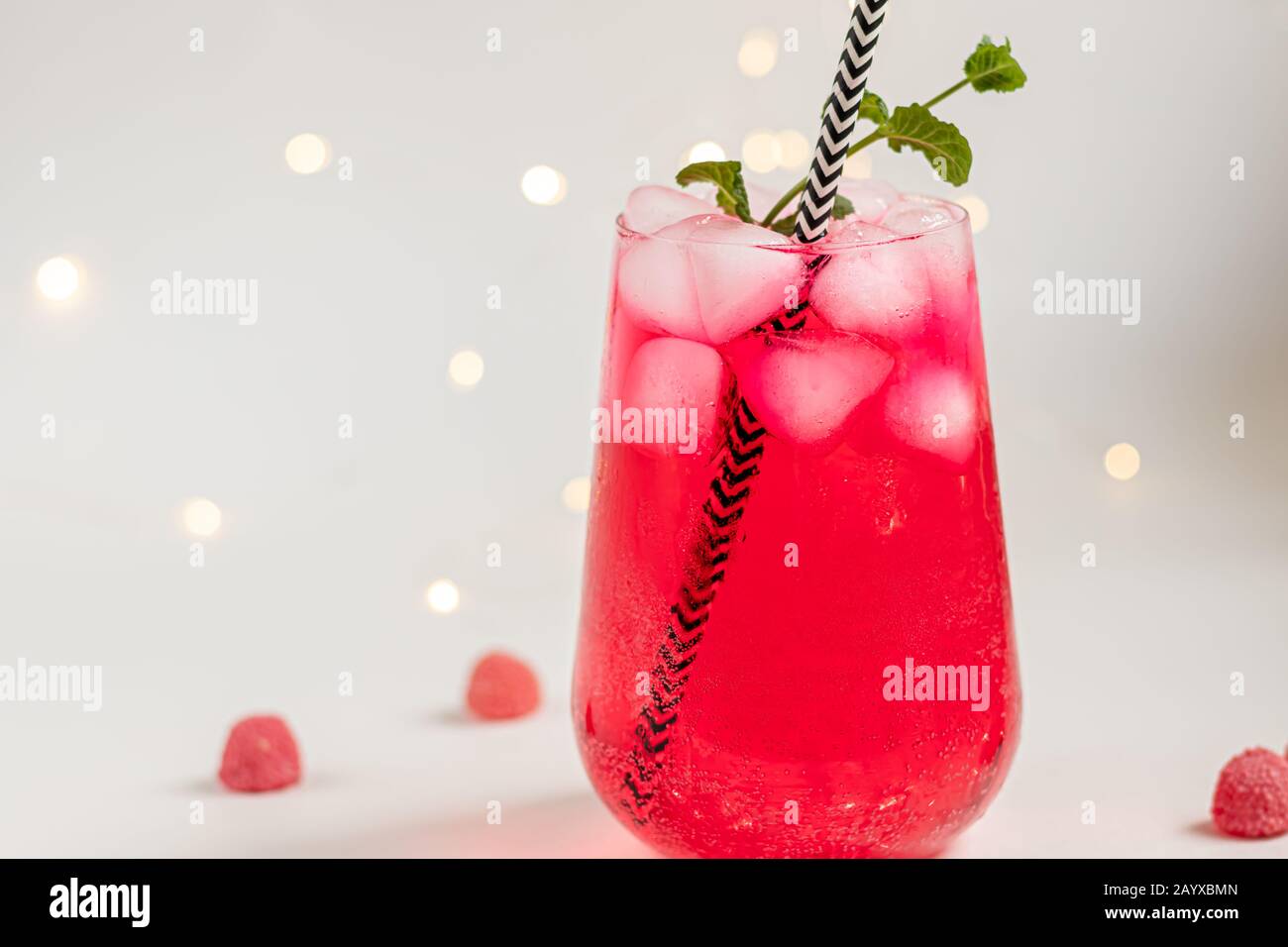 Raspberry-barberry drink in a transparent glass with ice. Added palm ...