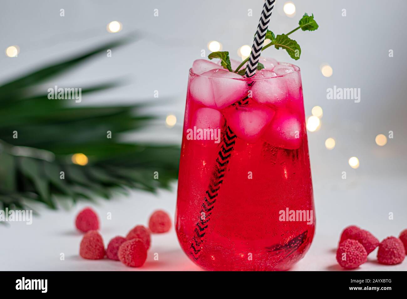 Raspberry-barberry drink in a transparent glass with ice. Added palm ...